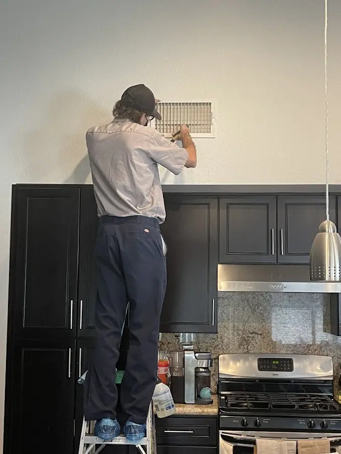 Technician inspecting an air vent during HVAC service in Weatherford
